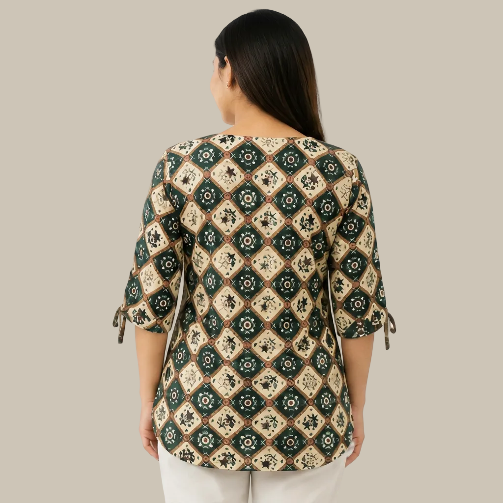 A woman shown from the back wearing a patterned three-quarter sleeve top with tie details at the cuffs, paired with light-colored pants, against a plain white background.