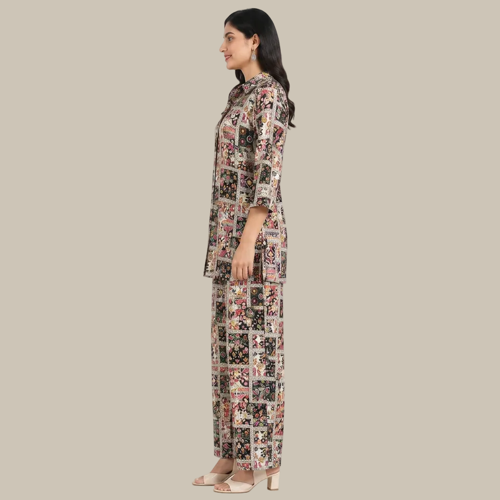 A woman modeling a matching two-piece pajama set with a busy multicolor patchwork print, shown in profile against a plain white background.