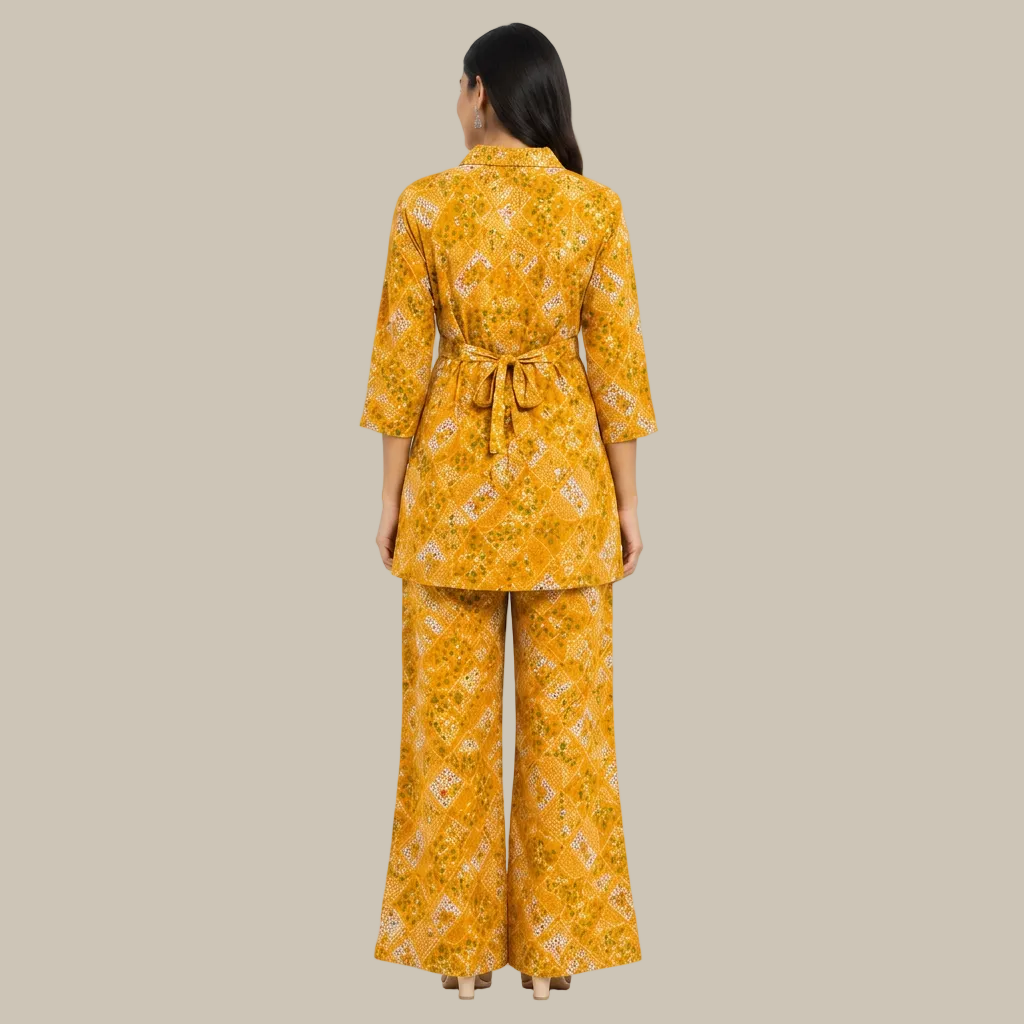 A woman viewed from the back wearing a matching two-piece outfit consisting of a yellow floral kimono-style top with a tie waist and wide-leg pants, on a plain white background.