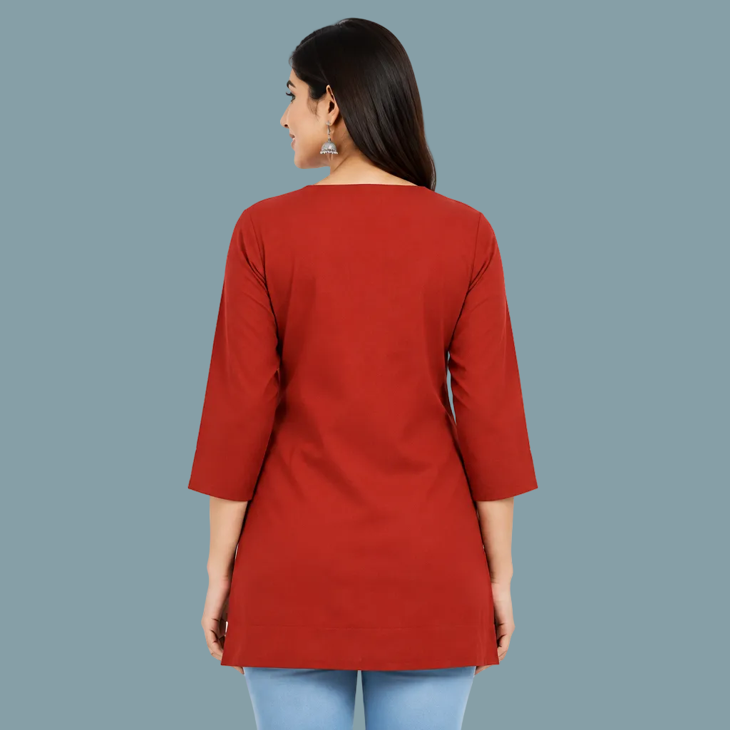 A woman shown from the back wearing a solid red three-quarter sleeve tunic top with a wide boat neckline, paired with light blue jeans, against a plain light gray background.